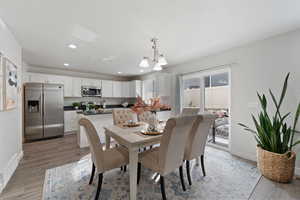 Dining room with lvp floors and an inviting chandelier