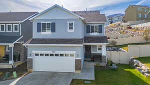 View of front of property with a front yard and a garage