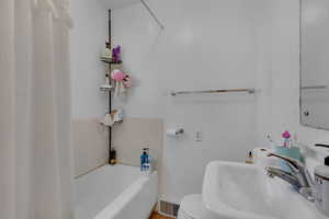 Bathroom featuring toilet, sink, and a bathtub