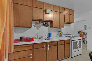 Kitchen featuring tile countertops, tasteful backsplash, and gas range gas stove