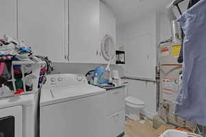 Laundry area featuring light hardwood / wood-style flooring, separate washer and dryer, and water heater