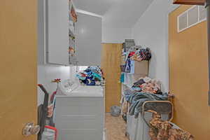 Clothes washing area with washer and clothes dryer and cabinets