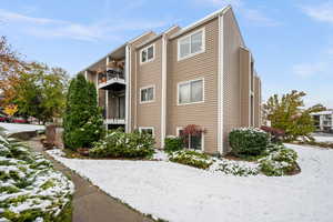 View of snowy exterior featuring a balcony