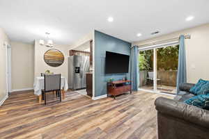 Living room with a chandelier and hardwood / wood-style flooring