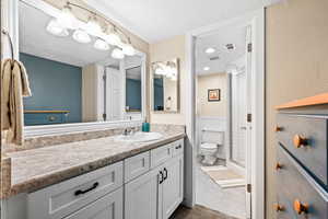 Bathroom featuring vanity, toilet, a shower with shower door, and tile patterned floors