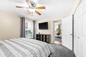 Bedroom featuring carpet flooring, multiple windows, ceiling fan, and a closet