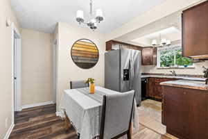 Dining area featuring a textured ceiling, sink, dark hardwood / wood-style floors, and an inviting chandelier