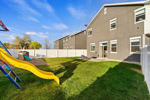 Exterior space featuring a playground, a yard, and a patio