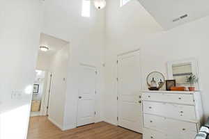 Interior space featuring light hardwood / wood-style flooring and a high ceiling