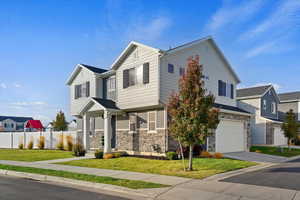 View of front of home with a front lawn and a garage