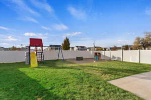 View of large fenced yard with a playground