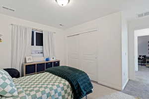 Carpeted bedroom with a closet and a textured ceiling