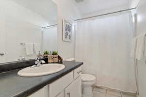 Bathroom with tile patterned flooring, vanity, and toilet