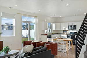 Kitchen featuring white cabinets, light wood-type flooring, sink, and black appliances