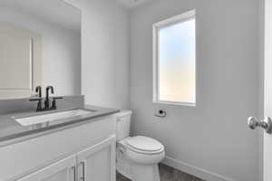 Bathroom with hardwood / wood-style flooring, vanity, and toilet