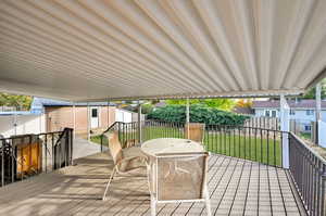 Wooden deck featuring a yard and a storage shed