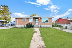 Bungalow-style home with a front yard and a carport / Green Grass edit to show potential