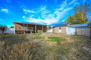 Rear view of house with an outbuilding and a wooden deck