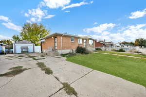 View of front facade featuring a front lawn, an outdoor structure, and a garage