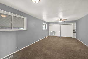 Unfurnished bedroom featuring a textured ceiling, ceiling fan, and carpet