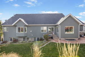 Rear view of property featuring a lawn and a patio area