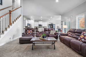 Living room featuring high vaulted ceiling and carpet