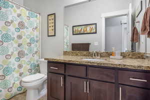 Bathroom featuring tile patterned flooring, vanity, and toilet