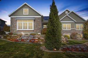 Craftsman house with solar panels and a lawn