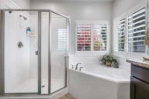 Bathroom featuring separate shower and tub, tile patterned flooring, and vanity