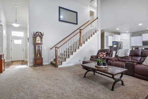 Carpeted living room featuring a high ceiling