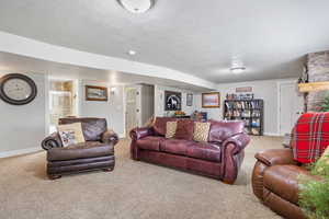 Carpeted living room with a fireplace and a textured ceiling