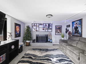 Carpeted living room with a fireplace, rail lighting, and a textured ceiling