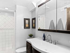 Bathroom with curtained shower, vanity, and toilet