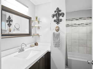 Bathroom featuring vanity and tiled shower / bath