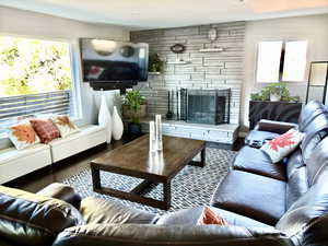 Living room with a fireplace and wood-type flooring