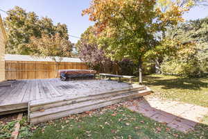 View of backyard deck and hot tub, looking westward, with firepit area in foreground.