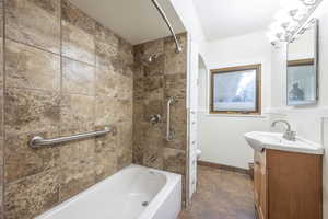 Full bathroom featuring vanity, toilet, and tiled shower/bath