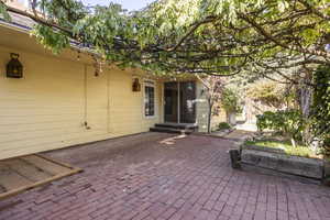 Wisteria-covered inner courtyard patio looking toward master suite studio