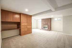 Basement family room with fireplace, built-in desk, cabinets, and drawers