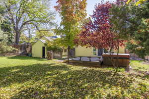 Back view showing storage shed, house, deck, and hot tub