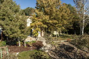 Front view of home with garden, fruit trees, and aspens