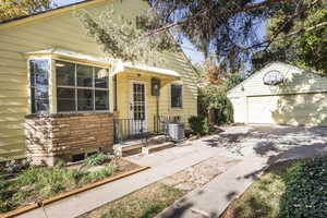 Side view of home with kitchen herb garden under bay window and 2-car garage