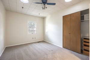 Bedroom 3 with west-facing window, ceiling fan, large closet with built-in drawers, and twoskylights