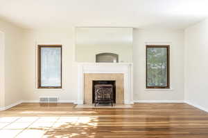 West wall of living room with gas-fired cast-iron stove and mirror (reflecting dining roomentrance)