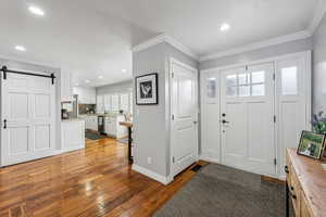 Foyer entrance featuring ornamental molding, dark wood-type flooring, and a textured ceiling