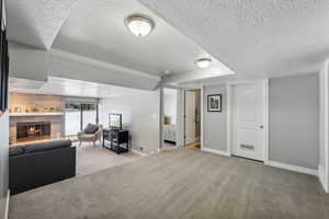 Carpeted living room with a textured ceiling