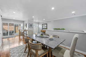 Dining room featuring wood-type flooring, a textured ceiling, and ornamental molding