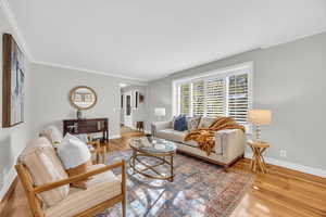 Living room with hardwood / wood-style floors and crown molding