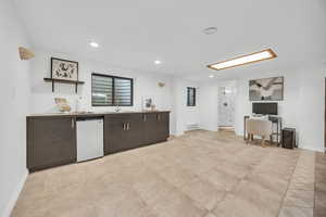 Kitchen featuring baseboard heating, dishwasher, sink, and dark brown cabinets