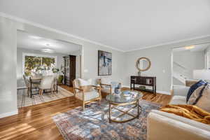 Living room with hardwood / wood-style flooring and ornamental molding